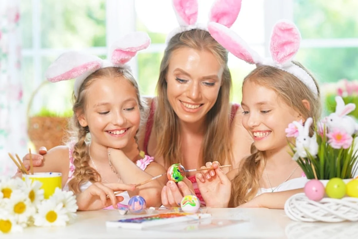 Matka z córkami ozdabiają jaja wielkanocne